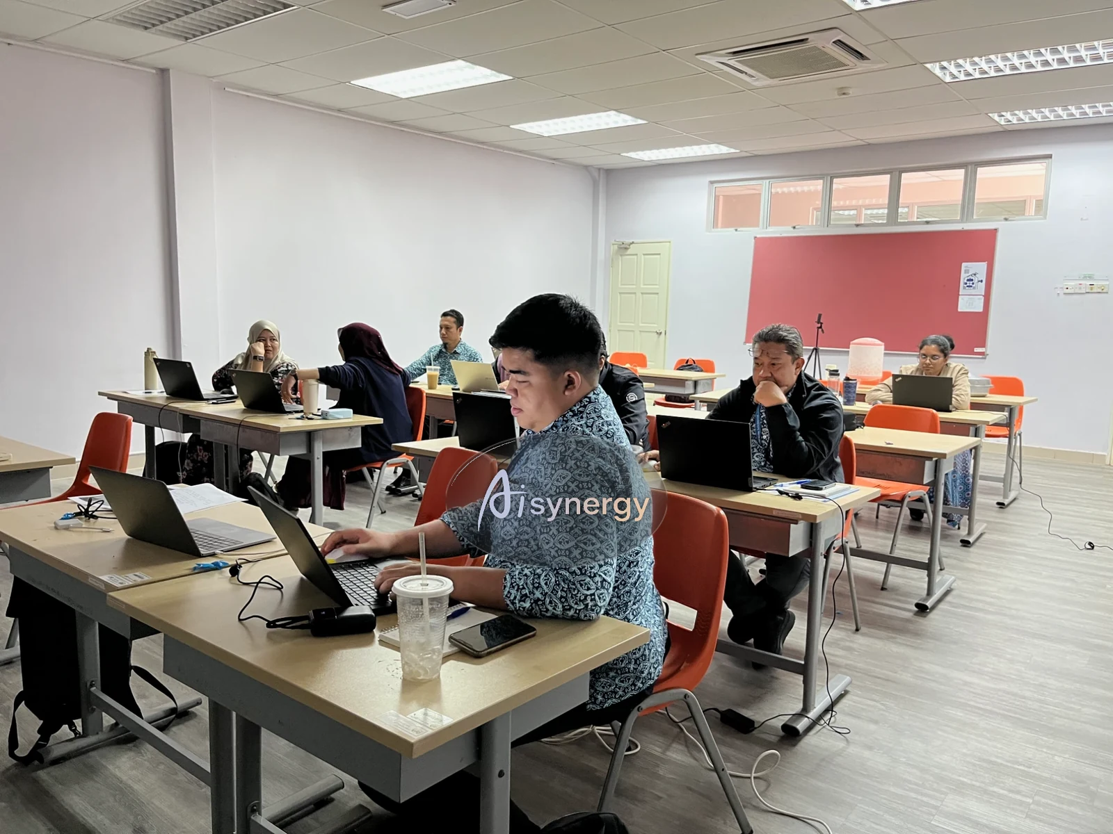 Participants working at their laptops during a classroom-style training session