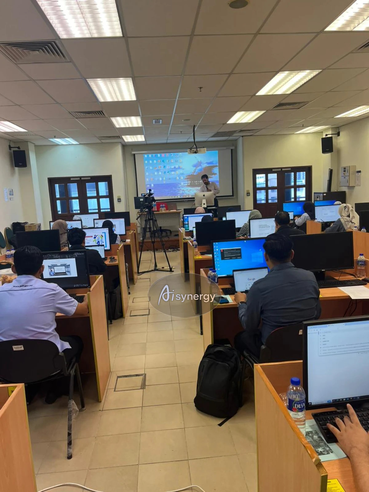 Wide view of a computer-lab training session with participants at their desks